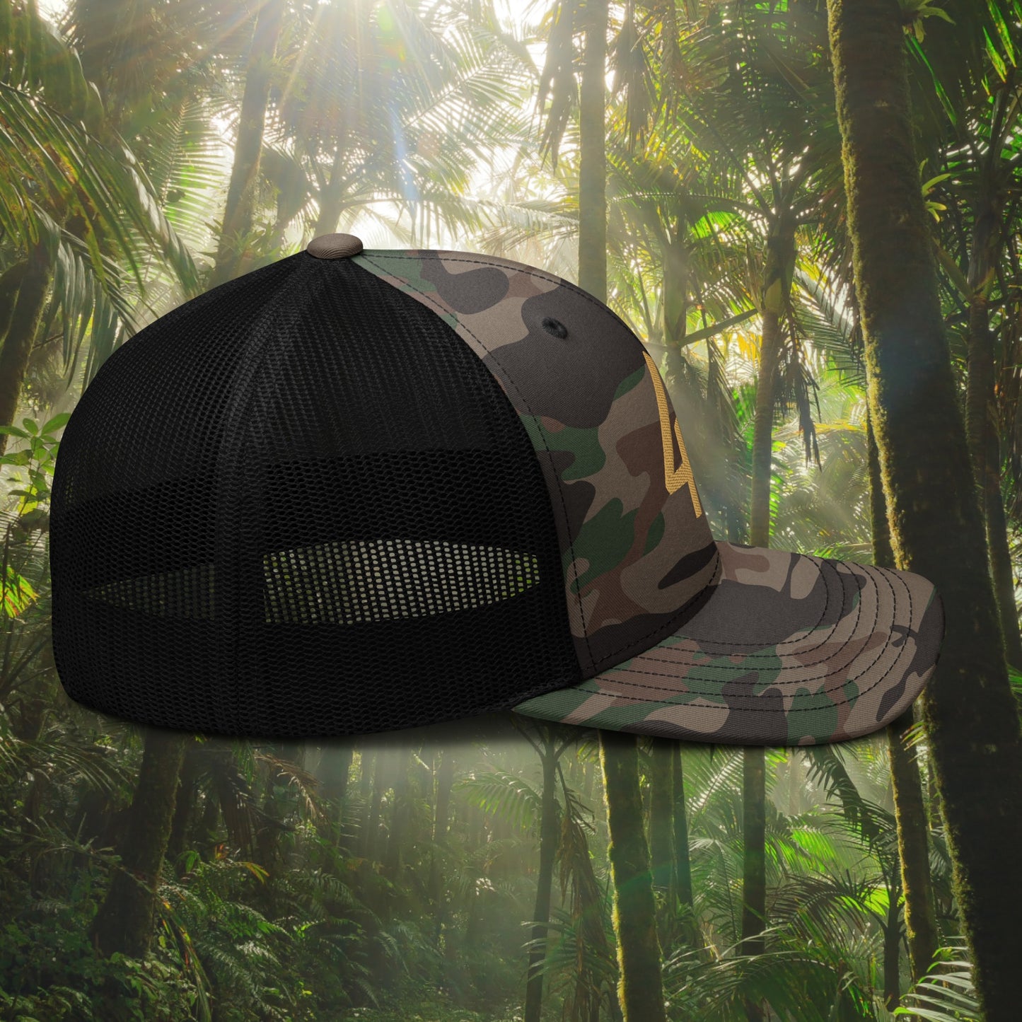 Camouflage and black mesh cap against a tropical forest background